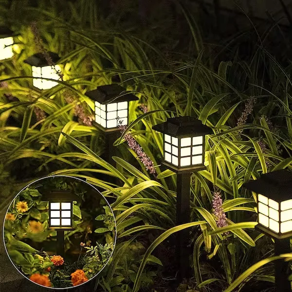 Heritage lantern-style solar path lights glowing among garden plants at night