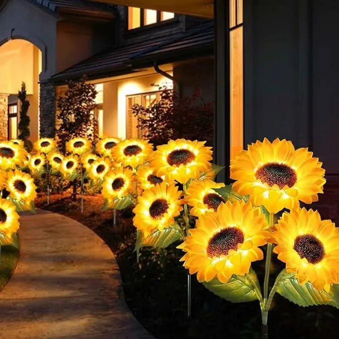 Solar sunflower stake lights glowing along a front yard path at night